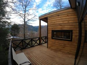 una gran terraza de madera en el lateral de una casa en BordeArroyo Malalcahuello, en Malalcahuello