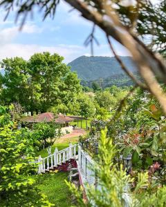 a white fence in a garden with a mountain in the background at Beyaz Köşk Geyve in Geyve