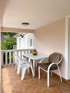 Village house Iva في فيربازار: طاولة بيضاء وكراسي على شرفة