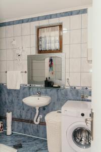 a bathroom with a sink and a washing machine at Sarajevo Central View Apartment in Sarajevo
