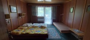 a small room with two beds and a window at Penzion Svojanov in Svojanov