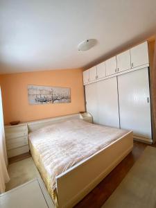 1 dormitorio con 1 cama grande y armarios blancos en Village house Iva, en Virpazar