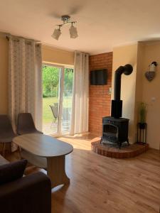 a living room with a wood stove in a room at Mazurski domek in Mrągowo