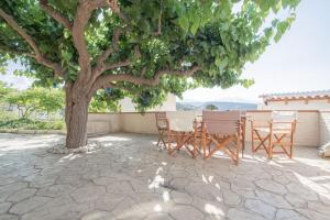 a table and chairs under a tree on a patio at Mulberry tree villa in Agios Nikolaos