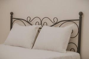 Cama en blanco y negro con almohadas blancas en Mulberry tree villa en Ágios Nikólaos