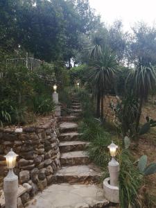 un camino de piedra en un jardín con una pared de piedra en La Mhirabelle, en Saint-Paul-de-Vence