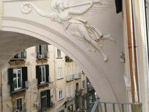 Una statua di una donna sul lato di un edificio di Chiaia Bridge B&B a Napoli