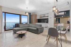 uma sala de estar com um sofá e uma mesa em Gioia Sea View em Mamaia Nord – Năvodari