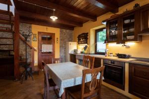 a kitchen with a table and a dining room at Tinčeva hiša in Kanal