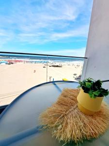 einen Glastisch mit einer Pflanze auf einem Strand in der Unterkunft Vila Thassos Sea View pe plaja Belona in Eforie Nord