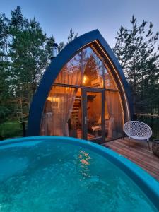 a dome house with a swimming pool at Jungle SPA bungalows in Žocenes Ciems