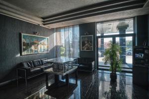 a living room with a glass table and a couch at Hotel Uzhgorod in Uzhhorod