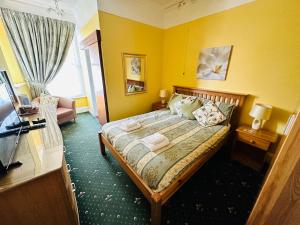 sypialnia z łóżkiem w żółtym pokoju w obiekcie Perfect for large groups! w mieście Torquay