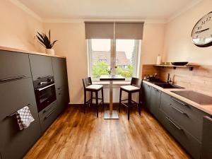 a kitchen with a sink and a counter with chairs at Ferienwohnung Kaiserglück in Goslar