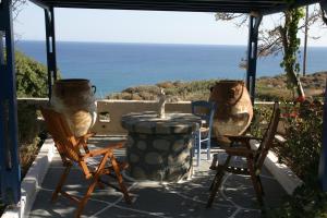 a patio with chairs and a table with a view of the ocean at Summer Residence in Provatas