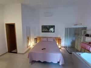 a bedroom with a bed and a glass shower at Recanto da Floresta Suítes in Petrópolis