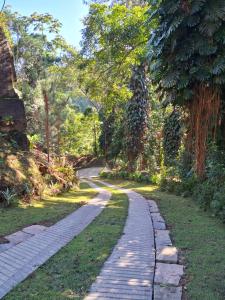 una strada di ciottoli in un parco alberato di Recanto da Floresta Suítes a Petrópolis