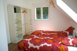 Schlafzimmer mit einem Bett mit einer roten und weißen Bettdecke in der Unterkunft Maison à Rouen jusqu'à 6 personnes, centre-ville in Saint-Léger-du-Bourg-Denis