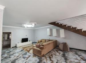 ein Wohnzimmer mit einem Sofa und einer Treppe in der Unterkunft Voyage Gabala in Qəbələ