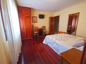 1 dormitorio con 1 cama y comedor con mesa en Hotel Liñares, en Poio
