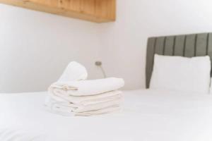 een stapel handdoeken zittend op een bed bij Sleek & Central 2BD Flat - Haymarket in Edinburgh