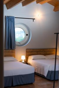 2 camas en una habitación con ventana en LPH - Dannunziano Country House, en Chieti