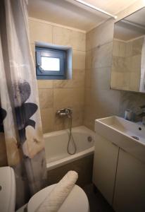 e bagno con servizi igienici, lavandino e vasca. di Hytra view house a Citèra (Kýthira)