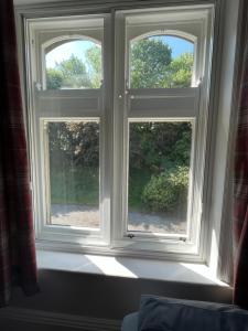 2 fenêtres dans une chambre avec un rebord de fenêtre dans l'établissement Hargate Hall Self Catering, à Buxton