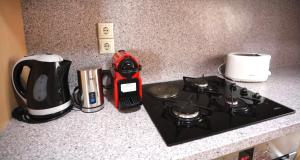 um balcão de cozinha com um fogão e comodidades para preparar café em Hytra view house em Citera