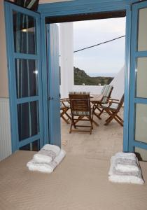 a room with a balcony with chairs and a window at Hytra view house in Kythira