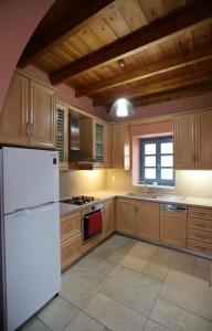 a kitchen with a white refrigerator and a window at Hytra view house in Kythira