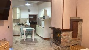 a kitchen with a fireplace and a table and chairs at Da Valentino e Manuela in Barberino di Mugello