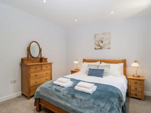 um quarto com uma cama grande e toalhas em Stag Cottage em Poole