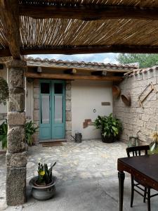 un patio con una puerta verde y una mesa en Graziosa stanza campidanese Su terzu, en Oristano