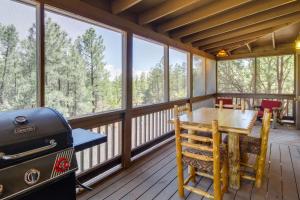 a screened in porch with a table and a grill at Scenic Arizona Cabin Rental Near Show Low Lake! in Show Low