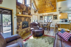 a living room with couches and a stone fireplace at Scenic Arizona Cabin Rental Near Show Low Lake! in Show Low