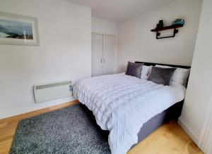 - une chambre blanche avec un grand lit dans l'établissement The Pilots Apartment, à Bournemouth