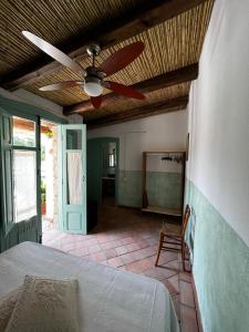 - une chambre avec un ventilateur de plafond et un lit dans l'établissement Graziosa stanza campidanese Su terzu, à Oristano