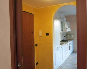 a kitchen with an archway and a yellow wall at Appartamento Malpensa Rho in Samarate +54 photos