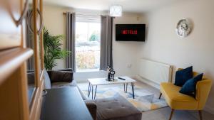 a living room with a couch and a table at Modern Marvel in Whaddon