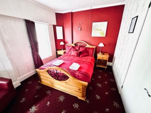a bedroom with a wooden bed with red walls at Perfect for large groups! in Torquay