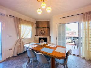 a dining room with a table and chairs and a fireplace at Almyriki Apartment in Ierissos