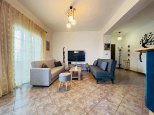 sala de estar con 2 sofás y TV en Almyriki Apartment, en Ierissos