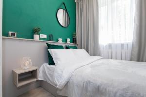 1 dormitorio con cama blanca y pared verde en MYFREEDOM Апартаменти метро Олімпійська Центр, en Kiev