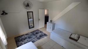 a room with a bed and a mirror and a dresser at CASA DU VÔ - Cantinho Du Vô in Santa Teresa