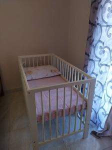 Renovated apartment 300m from the sea في إيريسوس: سرير أطفال أبيض مع وسادة في الغرفة