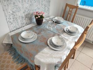 - une table à manger avec des assiettes et de la vaisselle dans l'établissement Garden Cottage, à Guisborough