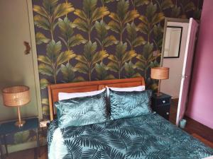 a bedroom with a bed with a tropical wallpaper at Garden Cottage in Guisborough