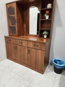 um grande armário de madeira com um espelho num quarto em Galaxy Guest Home by Ipoh Maju Stay em Ipoh