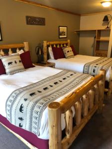 dos camas sentadas una al lado de la otra en una habitación en Summit Lake Lodge en Summit Lake